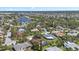 An aerial view showcases a serene neighborhood near a river, surrounded by lush greenery and single-Gathering homes at 5507 Nimitz Rd, New Port Richey, FL 34652