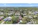 Aerial view of a lovely neighborhood surrounded by lush trees, with a lake in the distance at 5507 Nimitz Rd, New Port Richey, FL 34652
