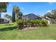 Landscaped backyard features an enclosed pool area with lush tropical plants and green grass at 5507 Nimitz Rd, New Port Richey, FL 34652