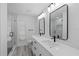 Modern bathroom with double vanity, framed mirrors, black hardware, and a glass enclosed shower at 5507 Nimitz Rd, New Port Richey, FL 34652