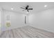 Spacious bedroom featuring light gray vinyl floors, a ceiling fan, and two windows for natural light at 5507 Nimitz Rd, New Port Richey, FL 34652
