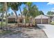 Charming single-Gathering home featuring an attached two-car garage, stone accents, landscaped yard with palm trees, and a driveway at 5507 Nimitz Rd, New Port Richey, FL 34652