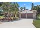 Charming single-Gathering home featuring an attached two-car garage, landscaped yard with palm trees, and a spacious driveway at 5507 Nimitz Rd, New Port Richey, FL 34652