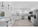 Bright kitchen features white cabinets, stainless steel appliances, stone countertops and a view of the pool at 5507 Nimitz Rd, New Port Richey, FL 34652