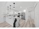 Modern kitchen boasts white cabinetry, stainless steel appliances, and a beautiful waterfall island with stone countertops at 5507 Nimitz Rd, New Port Richey, FL 34652