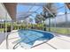 Enclosed pool with blue tile surrounded by a white deck and featuring a spa and handrails at 5507 Nimitz Rd, New Port Richey, FL 34652