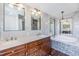 Bathroom featuring double sink vanity, soaking tub with tile surround, and updated fixtures at 6036 110Th N Ave, Pinellas Park, FL 33782