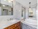 Bathroom with marble tile, double sink vanity, soaking tub, and modern lighting at 6036 110Th N Ave, Pinellas Park, FL 33782