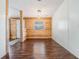 Dining room with hardwood floors featuring a rustic light fixture, wood paneling, and bright open spaces at 6036 110Th N Ave, Pinellas Park, FL 33782