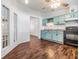 Bright kitchen features wooden floors, soft blue cabinetry, black appliances, and natural light at 6036 110Th N Ave, Pinellas Park, FL 33782