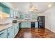 Bright kitchen features wooden floors, and soft blue cabinetry with modern black appliances at 6036 110Th N Ave, Pinellas Park, FL 33782
