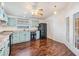 Bright kitchen features wooden floors, soft blue cabinetry, black appliances, and lots of natural light at 6036 110Th N Ave, Pinellas Park, FL 33782
