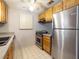 Modern kitchen with stainless steel appliances, wood cabinets, and white tile flooring at 6201 Amaretto Ln # 6201, Tampa, FL 33634