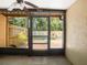 View of the screened porch with ceiling fan overlooking the backyard's greenery and painted fence at 6201 Amaretto Ln # 6201, Tampa, FL 33634