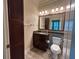 Well-lit bathroom with a dark wood vanity, granite countertop, and tiled floors at 622 Seascape Way, Tampa, FL 33602