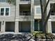 Exterior of condominium featuring garage, balcony, teal front door and mature landscaping at 622 Seascape Way, Tampa, FL 33602