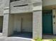 Exterior shot of condo with garage and green front door set in stucco wall at 622 Seascape Way, Tampa, FL 33602