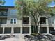Exterior of condominium featuring garage, balcony, teal front door and mature landscaping at 622 Seascape Way, Tampa, FL 33602