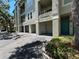Low angle exterior shot of condo featuring garage, balcony and teal front door at 622 Seascape Way, Tampa, FL 33602