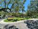 Scenic view of tree-lined street with lush landscaping, community fountain, and manicured grounds on a bright, sunny day at 622 Seascape Way, Tampa, FL 33602