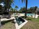 View of the pool area featuring lounge chairs and tiled fountains in a landscaped setting surrounded by palm trees at 622 Seascape Way, Tampa, FL 33602