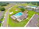 Overhead shot of community pool with lounge seating, amenity center, and recreational courts at 6384 Ten Acre Ct, Zephyrhills, FL 33541