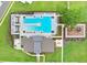 Aerial view of community pool area and playground, surrounded by lush landscaping at 6384 Ten Acre Ct, Zephyrhills, FL 33541