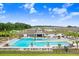 An aerial view of a pristine community pool and amenity center, highlighting its design at 6384 Ten Acre Ct, Zephyrhills, FL 33541