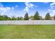 A level, grassy backyard is enclosed by a high, white fence for privacy at 6384 Ten Acre Ct, Zephyrhills, FL 33541
