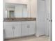 Bathroom featuring a large mirror and a granite countertop sink at 6384 Ten Acre Ct, Zephyrhills, FL 33541
