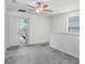 Bright bedroom features neutral walls, gray carpet and a modern ceiling fan at 6384 Ten Acre Ct, Zephyrhills, FL 33541