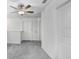 Bright bedroom features neutral walls, gray carpet and a modern ceiling fan at 6384 Ten Acre Ct, Zephyrhills, FL 33541