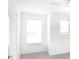 This bright bedroom features neutral walls, gray carpet and a double window at 6384 Ten Acre Ct, Zephyrhills, FL 33541