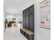 The entryway features a bench with storage and view to the spacious living room and dining room at 6384 Ten Acre Ct, Zephyrhills, FL 33541