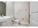 Bright half bathroom featuring a pedestal sink, standard toilet and a neutral color palette at 6384 Ten Acre Ct, Zephyrhills, FL 33541
