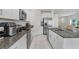 Modern kitchen featuring granite countertops, stainless steel appliances, and white cabinets at 6384 Ten Acre Ct, Zephyrhills, FL 33541