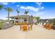 Outdoor pool area with comfortable lounge furniture, barbecues, and tables for dining at 6384 Ten Acre Ct, Zephyrhills, FL 33541