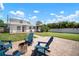Inviting backyard with a cozy fire pit area, Adirondack chairs, lush lawn, and a covered gazebo for outdoor relaxation at 656 40Th Ne Ave, St Petersburg, FL 33703