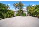 Charming white home surrounded by lush tropical landscaping and a shell driveway at 656 40Th Ne Ave, St Petersburg, FL 33703