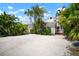 Charming white home with palm trees and lush landscaping, offering a tropical feel at 656 40Th Ne Ave, St Petersburg, FL 33703