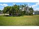 Lush front lawn with mature palm trees and vibrant green foliage surrounding the house at 656 40Th Ne Ave, St Petersburg, FL 33703