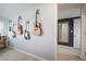 Hallway with wood floors and multiple guitars hanging on the wall near a doorway at 656 40Th Ne Ave, St Petersburg, FL 33703
