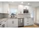 Bright kitchen with white cabinets, stainless steel appliances, and a granite countertop, herringbone backsplash at 656 40Th Ne Ave, St Petersburg, FL 33703