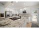 Well-lit kitchen featuring white cabinets, granite counters, stainless steel appliances, and island with cooktop at 656 40Th Ne Ave, St Petersburg, FL 33703