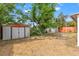 Expansive backyard featuring mature trees, utility sheds, and a stepping stone pathway, perfect for outdoor activities at 6982 78Th N Ave, Pinellas Park, FL 33781