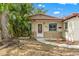 Charming single-story home with well-kept lawn, large tree, and inviting front entrance with colorful decorations at 6982 78Th N Ave, Pinellas Park, FL 33781