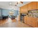 Open-concept kitchen with wooden cabinetry, granite countertops, and seamless access to a modern, sunlit living area at 6982 78Th N Ave, Pinellas Park, FL 33781