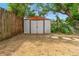 Backyard view of the metal storage shed, enclosed by a wood fence, providing secure storage for your outdoor needs at 6982 78Th N Ave, Pinellas Park, FL 33781