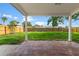 Covered back patio offers a peaceful spot with stone pavers, overlooking a well-maintained backyard at 7400 Belvedere Ter, New Port Richey, FL 34655