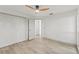 Bedroom featuring a ceiling fan, closet, and doorway, complemented by light-toned wood flooring at 7400 Belvedere Ter, New Port Richey, FL 34655